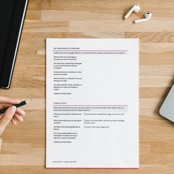 Creative project brief template for freelancers, studios and small businesses by Project Syntax Solutions shown on a desk