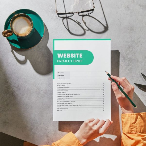Website project brief template for freelancers, studios and small businesses by Project Syntax Solutions shown on paper
