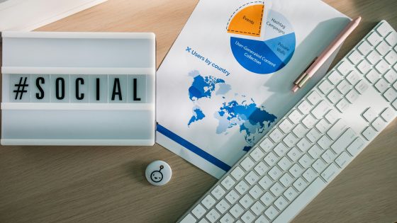 Desk with a light box with the hashtag #social, stationary elements and marketing stats